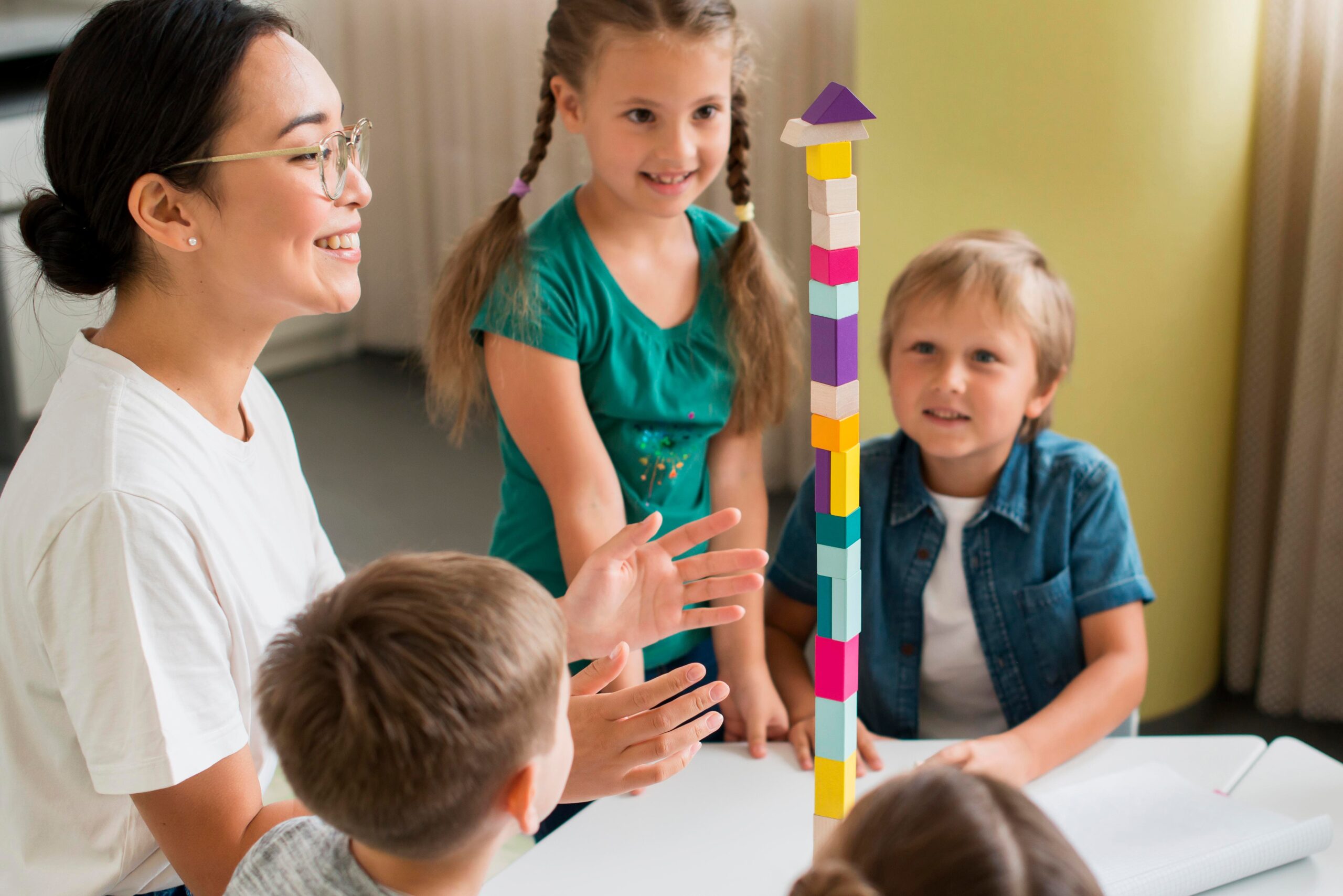 woman teaching kids how play with colorful tower 1 scaled
