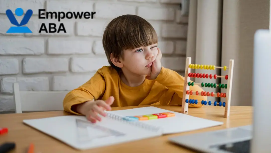 Young boy sitting at a table with an abacus and learning tools, resting his face on his hand with a smug expression, illustrating how autism affects brain processing.