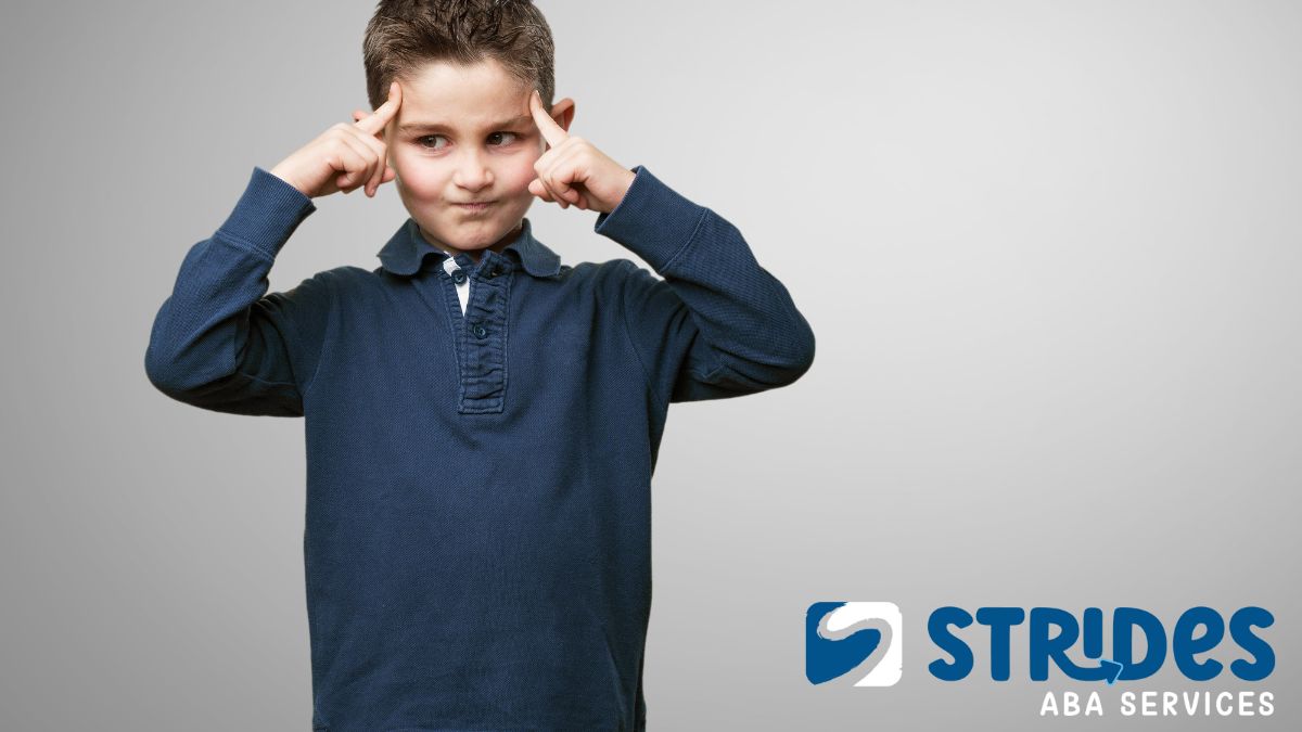 How to deal with overstimulation autism: a boy presses his pointer fingers to his forehead, focusing to calm himself.