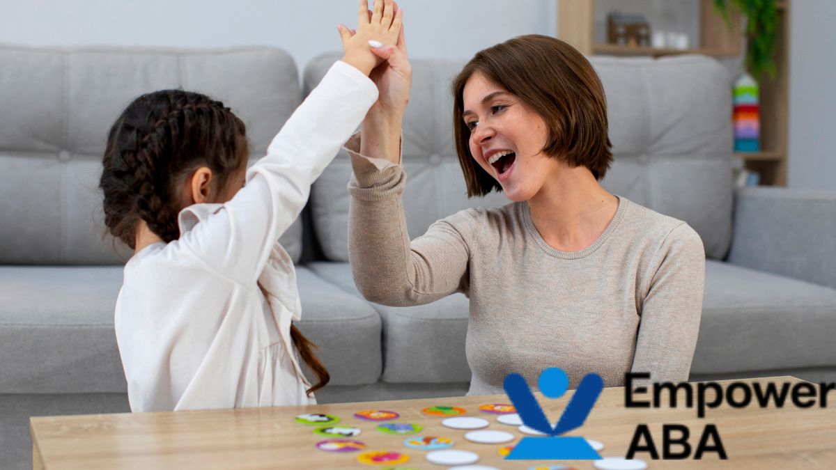 A female therapist and a child share a high five after completing a successful autism social skills session.