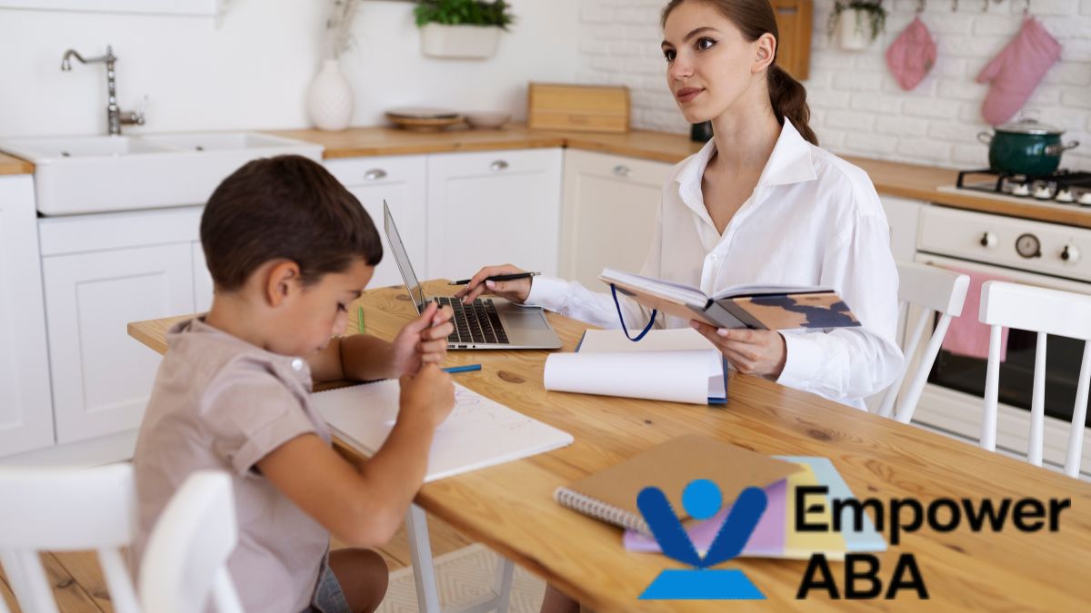 A female therapist guides a young child during an in-home autism social skills assessment in the kitchen area.